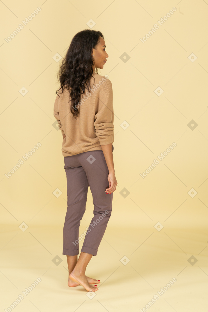 Vista traseira de uma jovem mulher com roupas casuais indo embora
