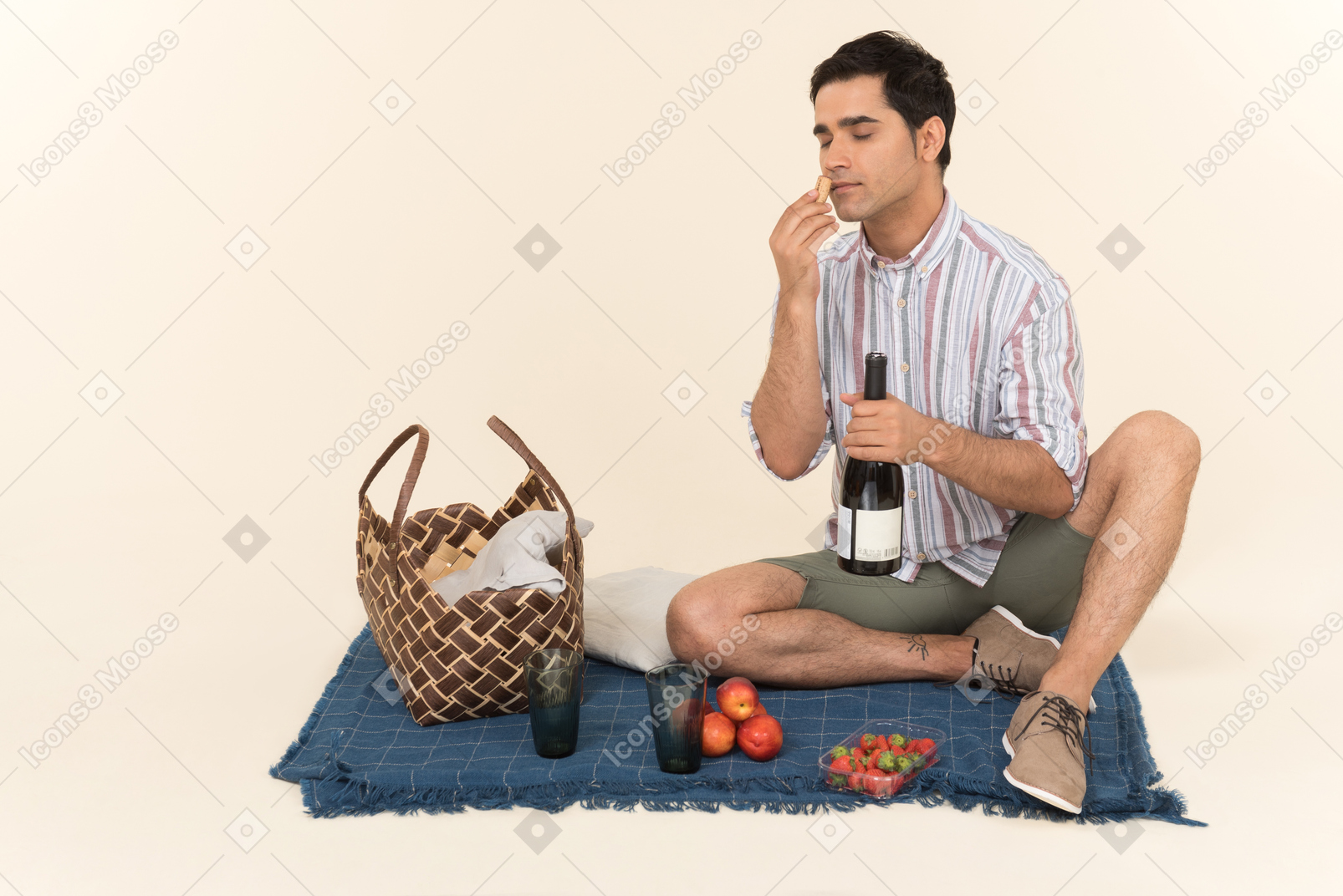 Junger kaukasischer kerl, der picknick hat und frucht riecht