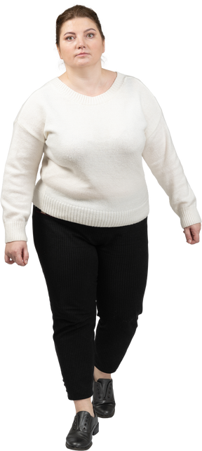 Front view of a plump woman in casual clothes walking