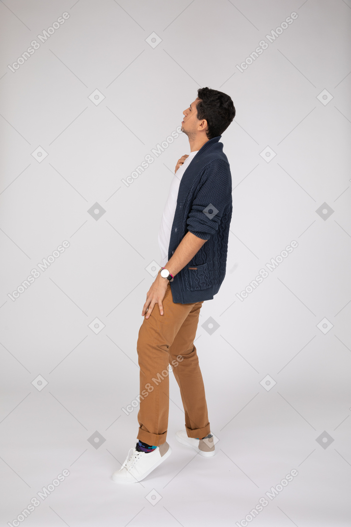 A man in a blue cardigan and tan pants