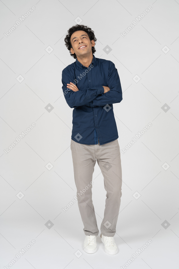 Vista frontale di un uomo in abiti casual in posa con le braccia incrociate