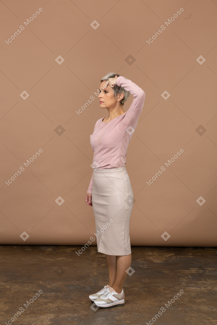 Vista lateral de uma mulher com roupas casuais tocando a cabeça com o dedo