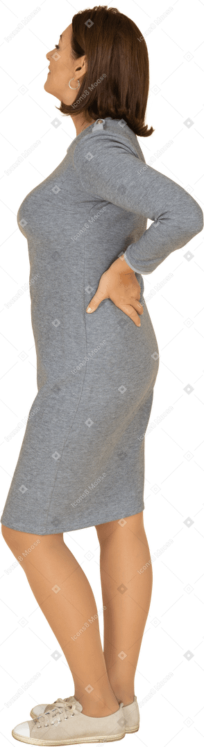 Vista lateral, de, un, mujer, en, vestido gris, posición, con, manos caderas