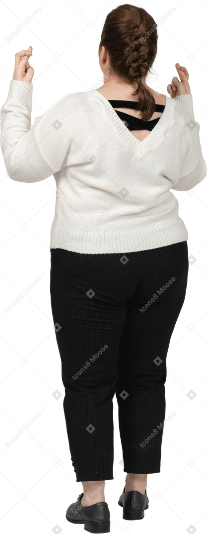 Rear view of a plus size woman in casual clothes crossing fingers