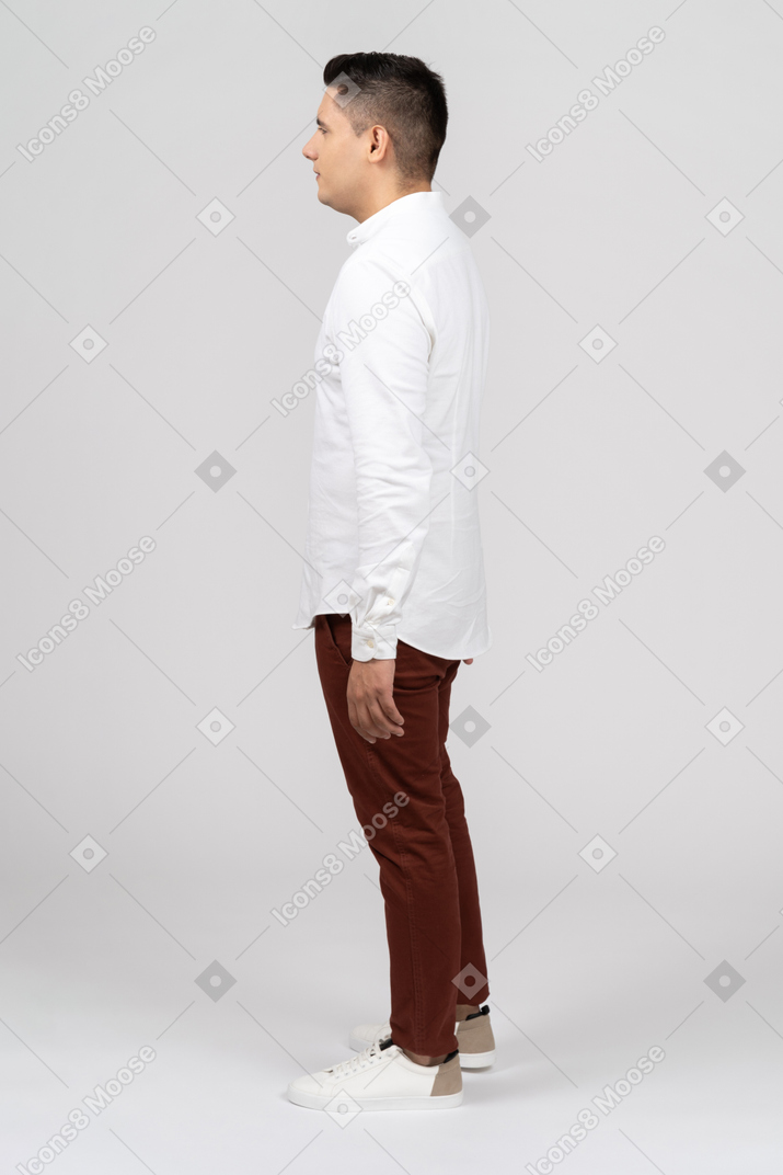 一个年轻的拉丁裔男子平静地站立的侧视图