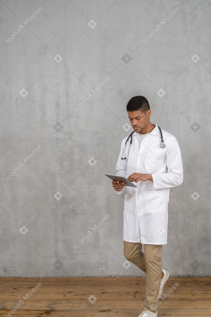 Medico maschio che esamina compressa mentre cammina