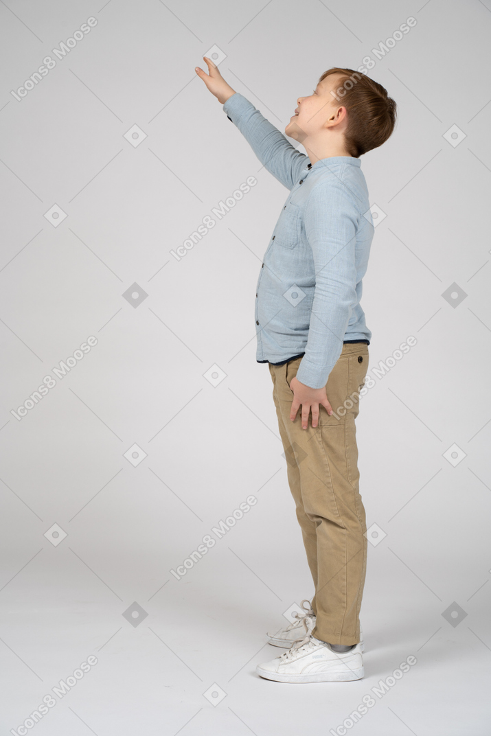一个快乐男孩抬头挥手的侧视图