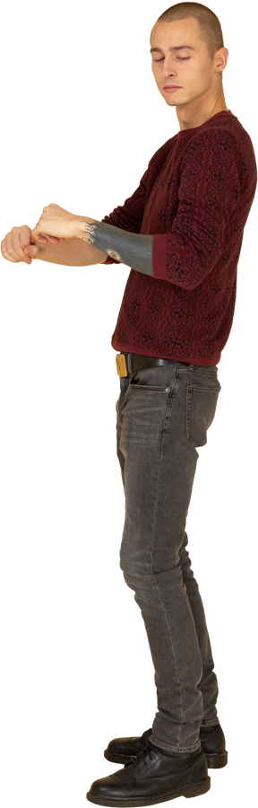 Vista laterale di un giovane uomo in pullover rosso stringendo i pugni
