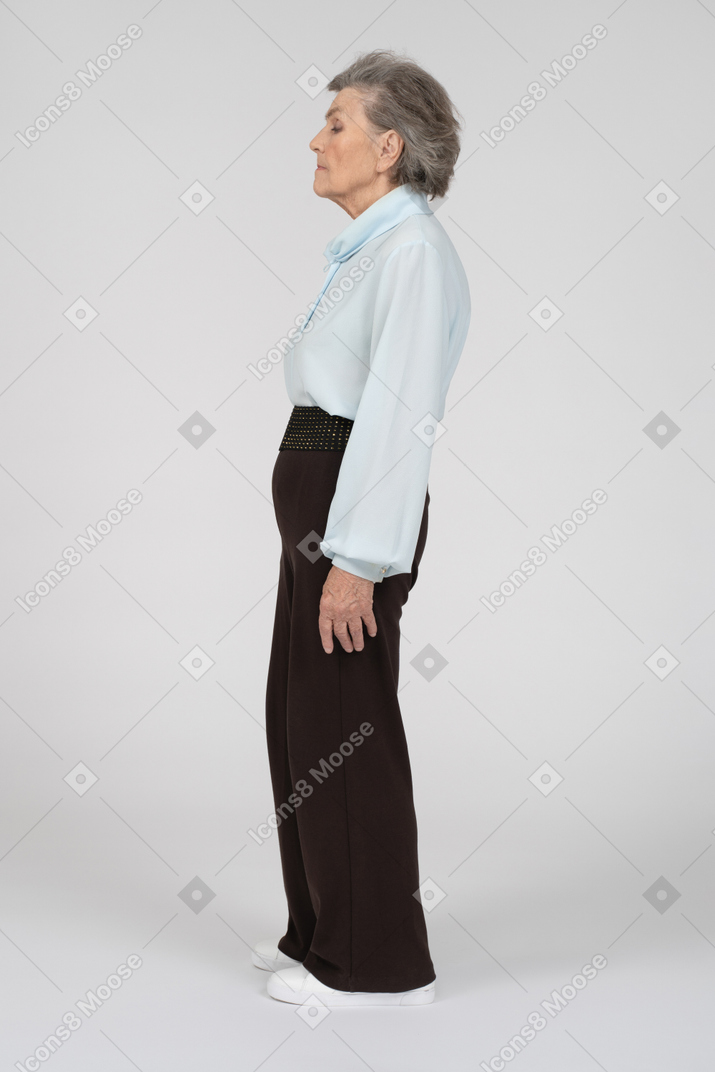Side view of old lady standing still with closed eyes