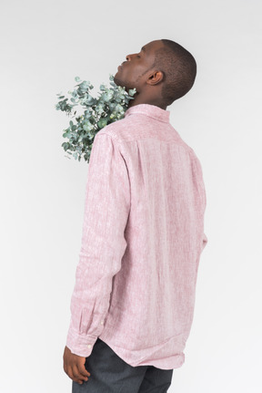 Good looking young man holding green branches