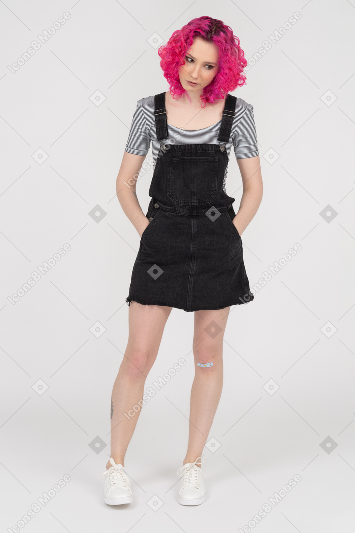 Concerned young woman posing with her hands in pockets