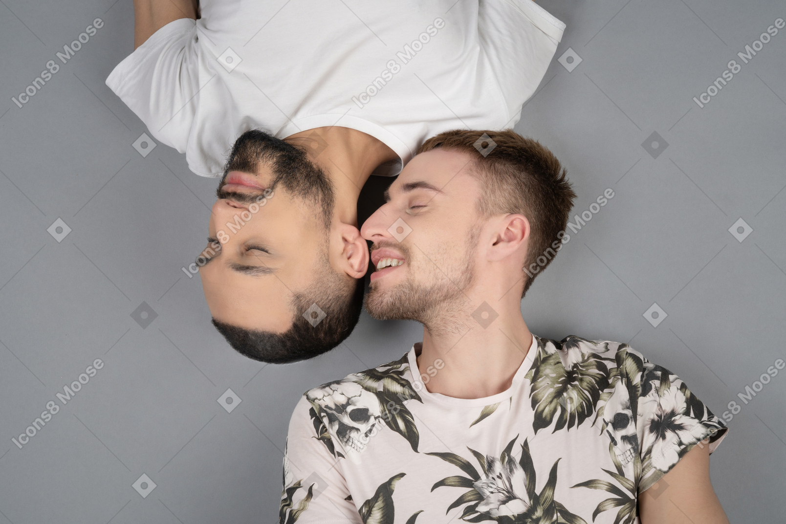 Flat lay of two young caucasian men lying head to head and smiling