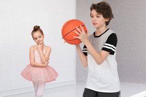 A girl in a tutu and a boy holding a basketball
