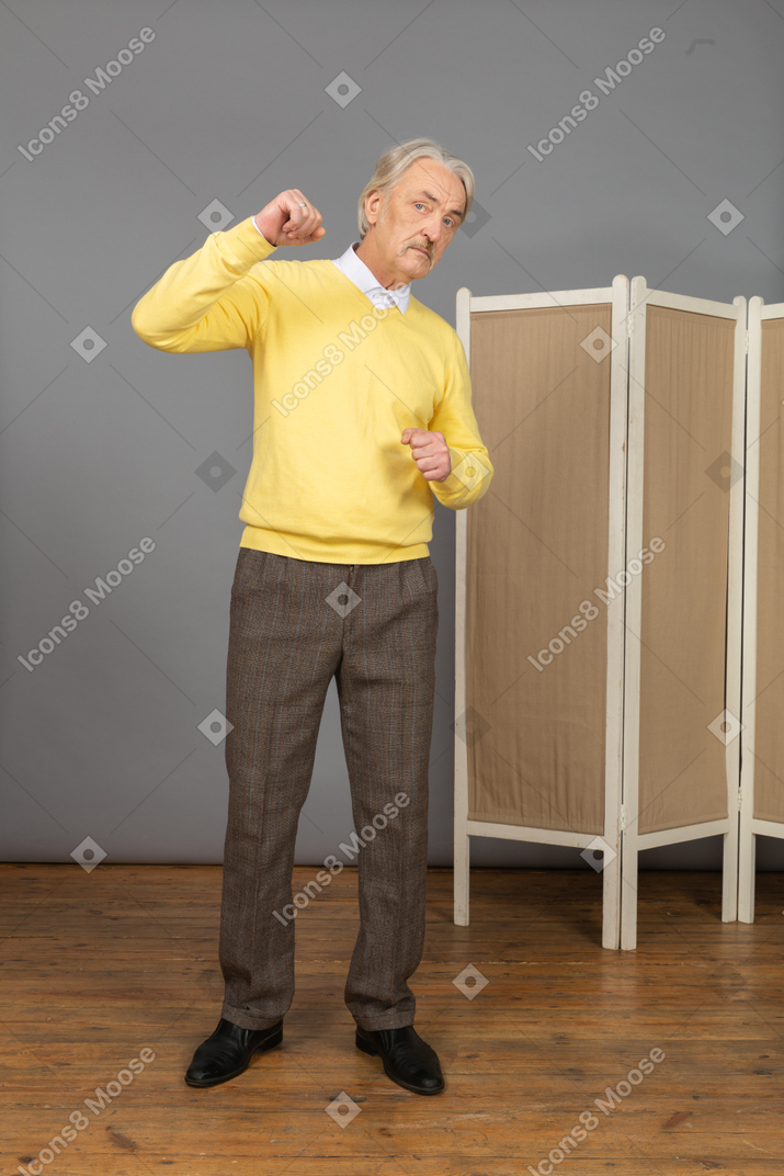 Vorderansicht eines alten mannes, der hand hebt und faust ballt