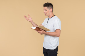 Young guy with prayer beads reading a bible