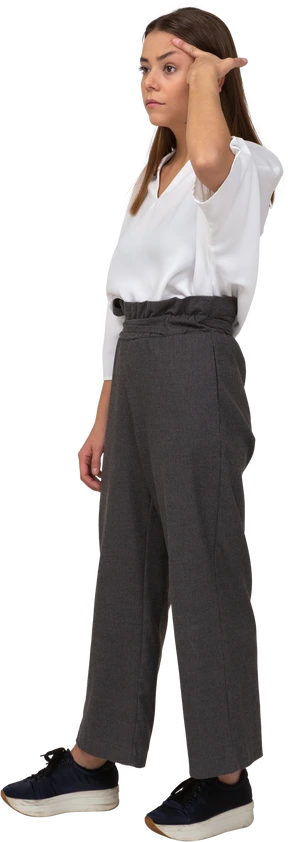 Three-quarter view of a young lady in office clothing looking aside & touching head