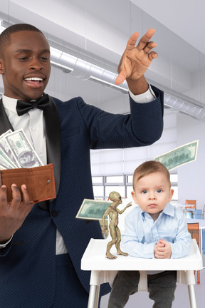 A man in a suit holding a wallet and a baby in a high chair