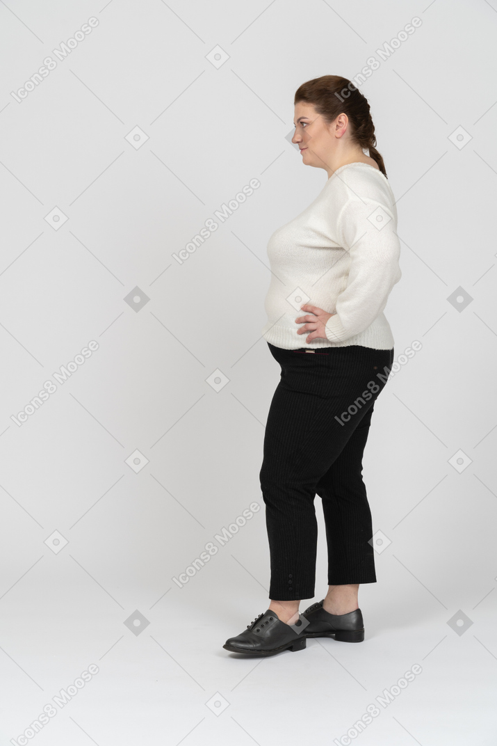 Taglie forti donna in maglione bianco in piedi con le mani sui fianchi