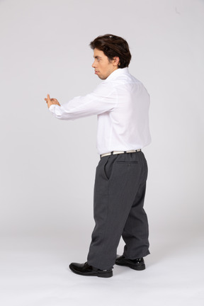Side view of a male office worker holding his hand out