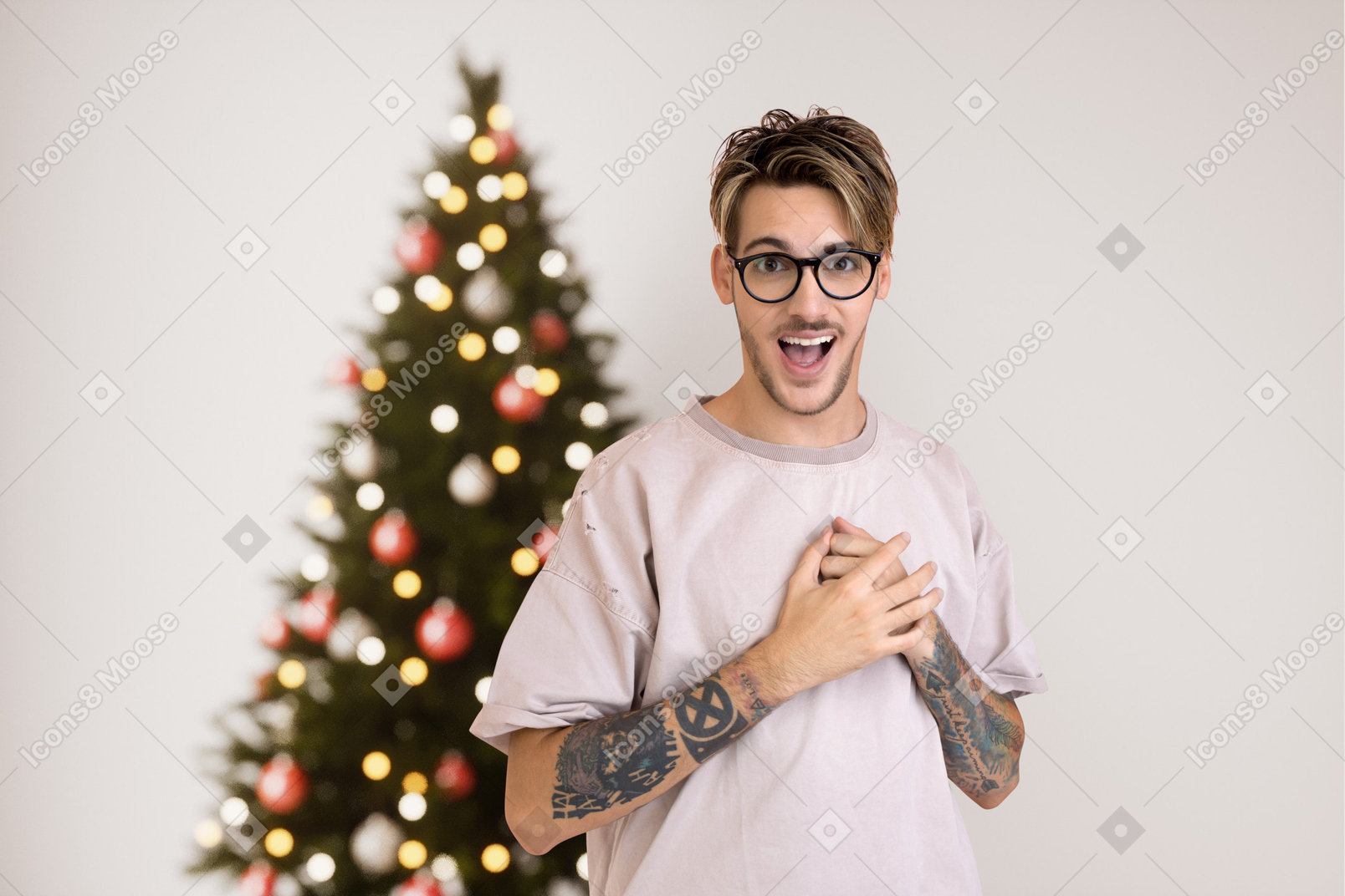 Young hipster guy near a christmas tree
