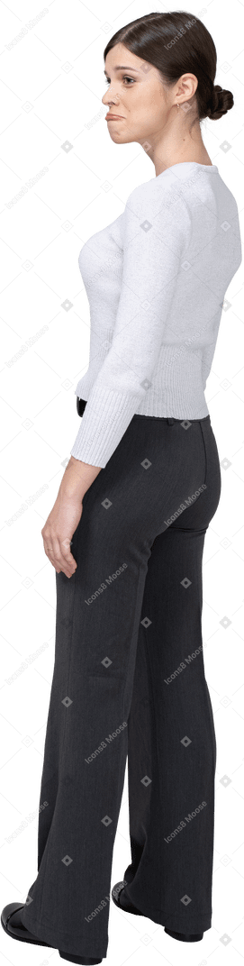 Three-quarter back view of a cute pouting woman in office clothing