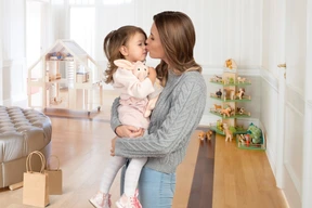 Madre sosteniendo a su hija en su sala de juegos
