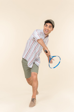 Giovane uomo caucasico che tiene la racchetta da tennis