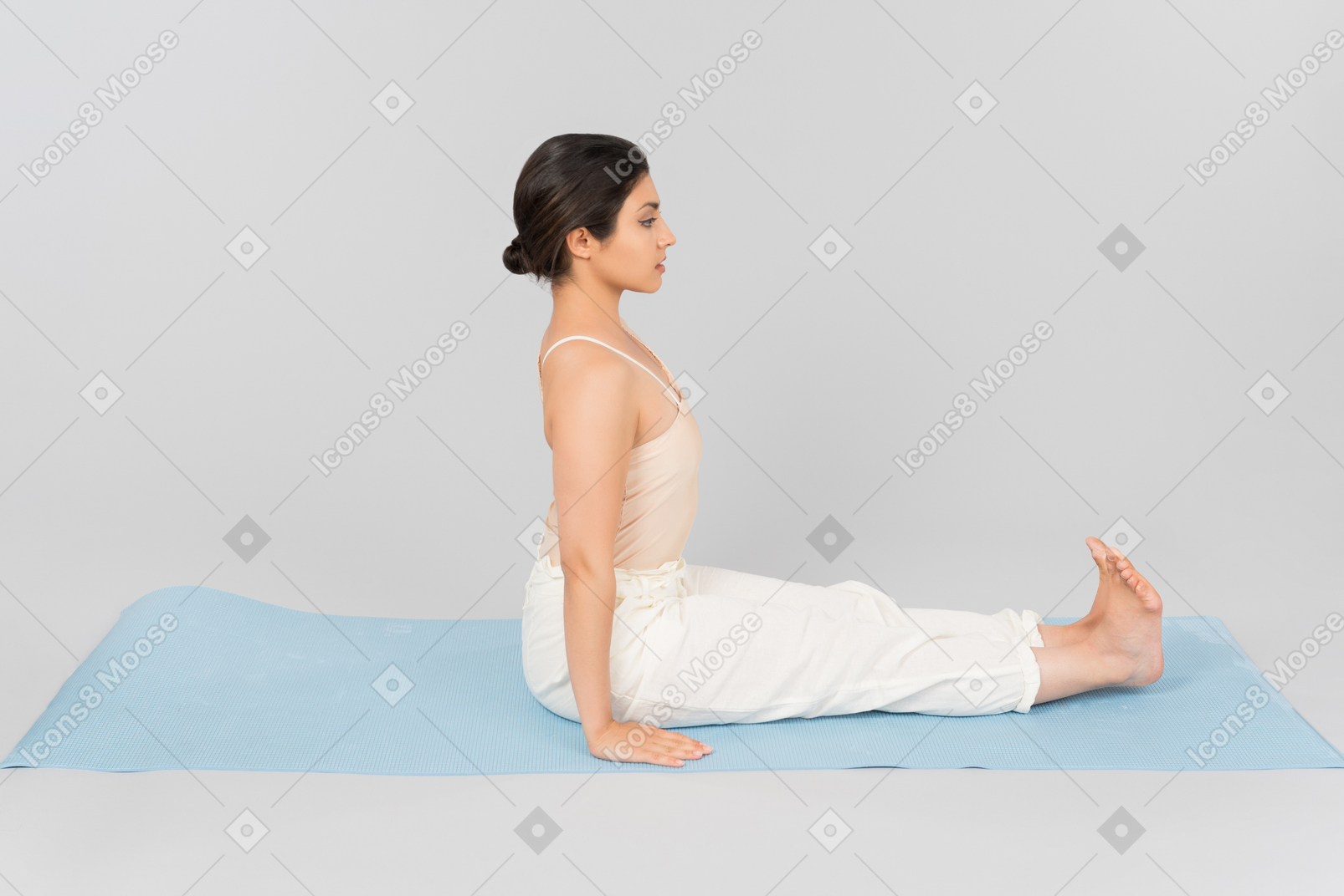 Young indian woman sitting with back straight on yoga mat