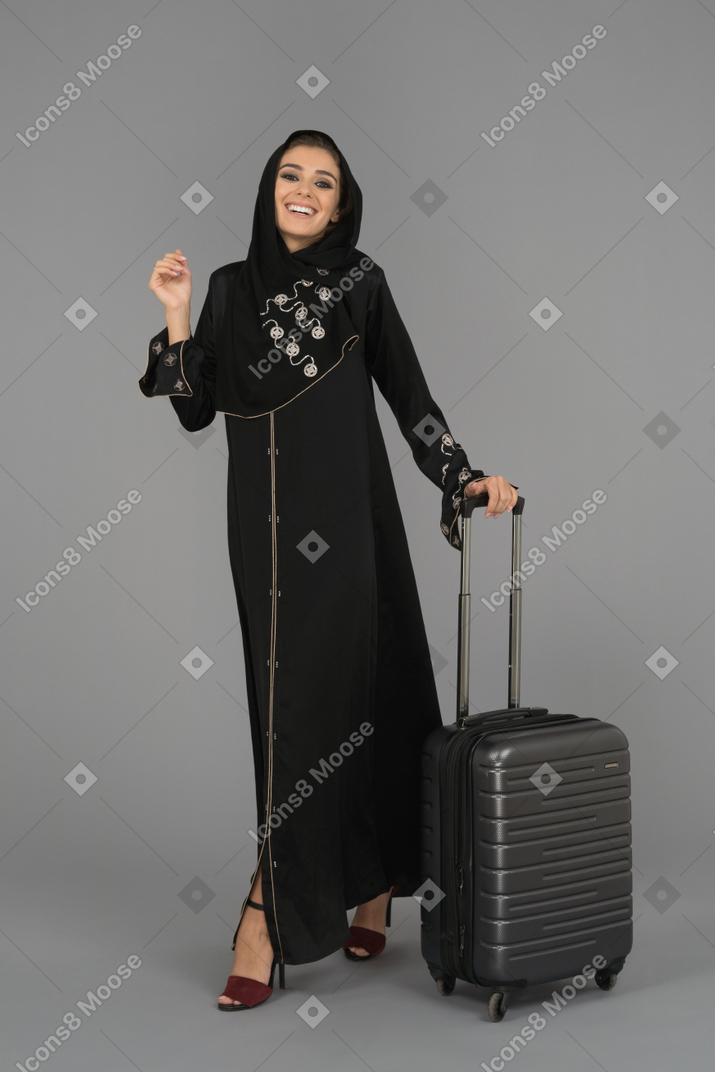 A cheerful arab woman walking with a bag