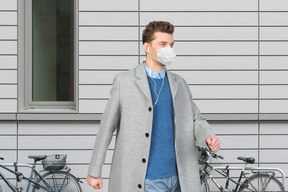 A man wearing a face mask walks down the street