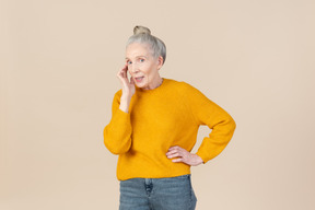 Elegante mujer mayor en un suéter de mostaza