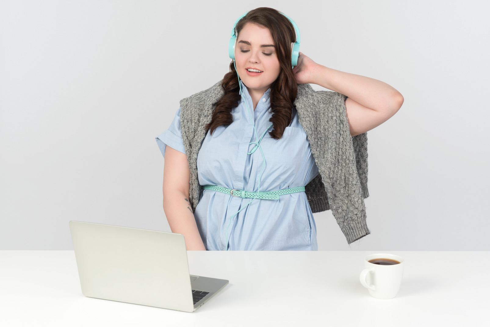 Calm young plus-size model listening to music on laptop