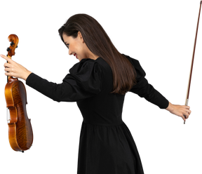 Three-quarter back view of a female violin player in black dress making a bow