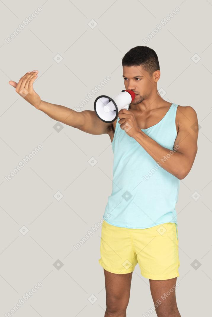 A man in shorts speaking into a megaphone