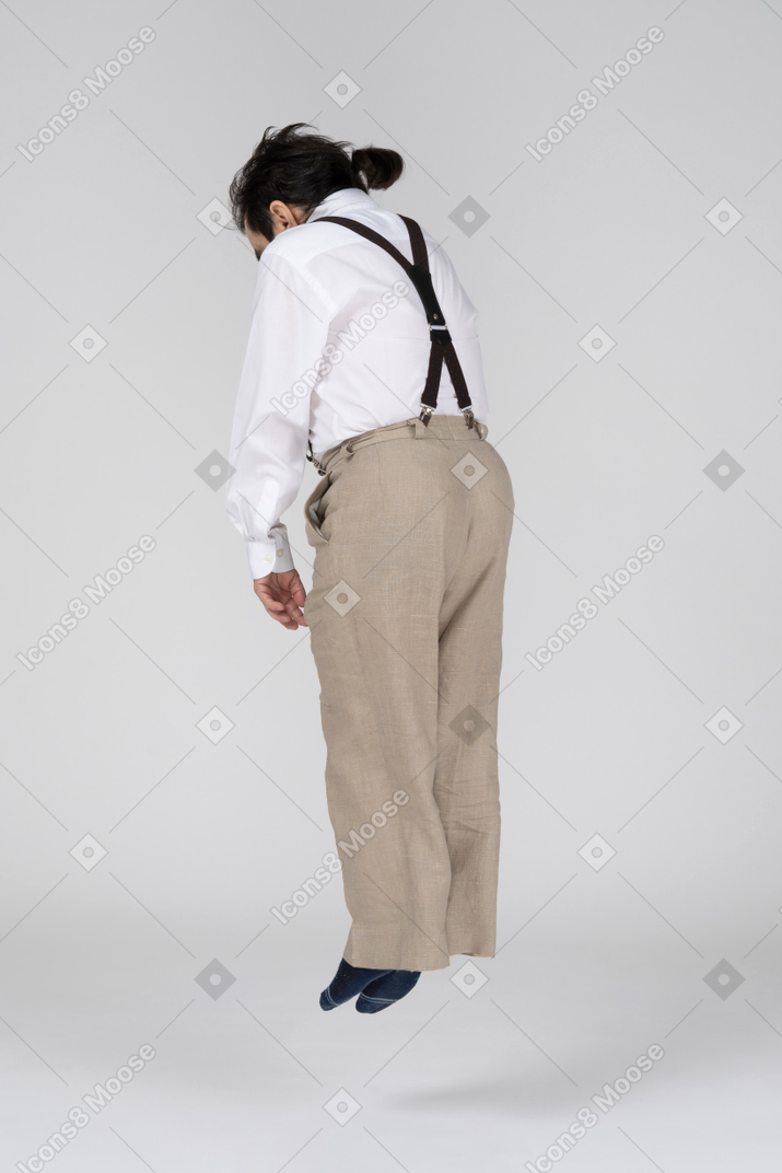 Man in suspenders levitating