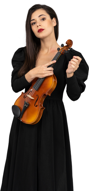 Vista frontal de uma jovem de vestido preto segurando o violino