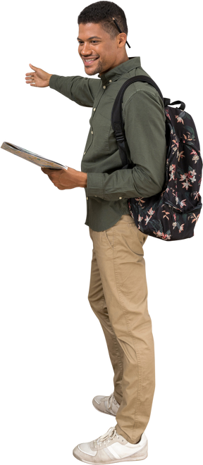 Vista lateral de un hombre con una mochila y un mapa que muestra direcciones y sonriendo