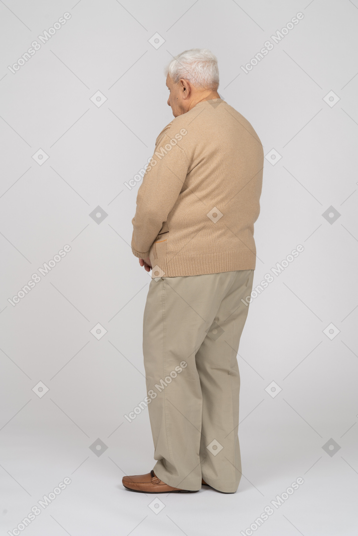 Side view of an old man in casual clothes standing still