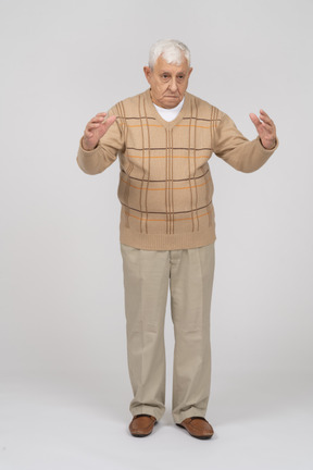 Vista frontal de um velho em roupas casuais, mostrando o tamanho de algo