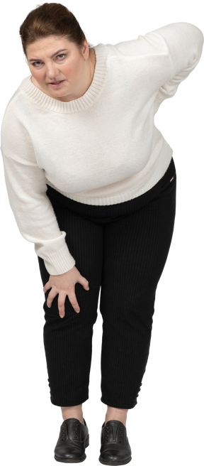Donna grassoccia in abiti casual che soffre di dolore nella parte bassa della schiena