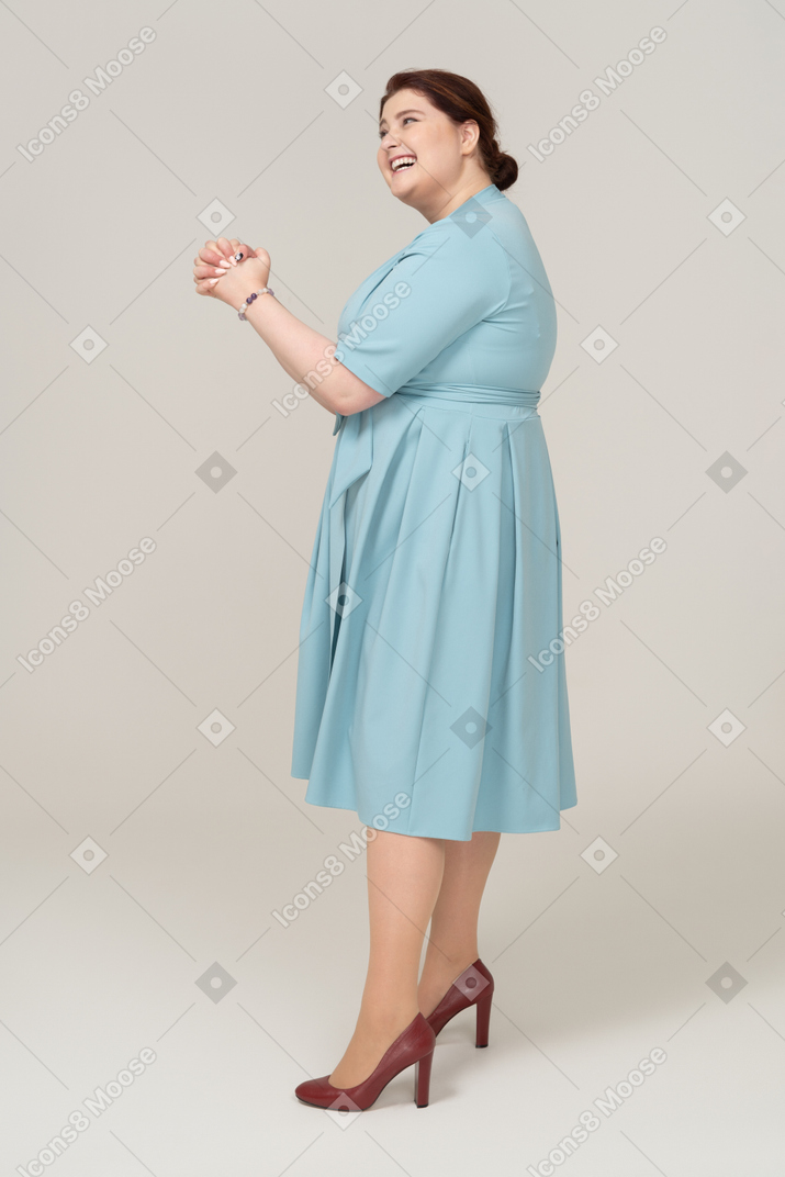 Vista laterale di una donna felice in abito blu
