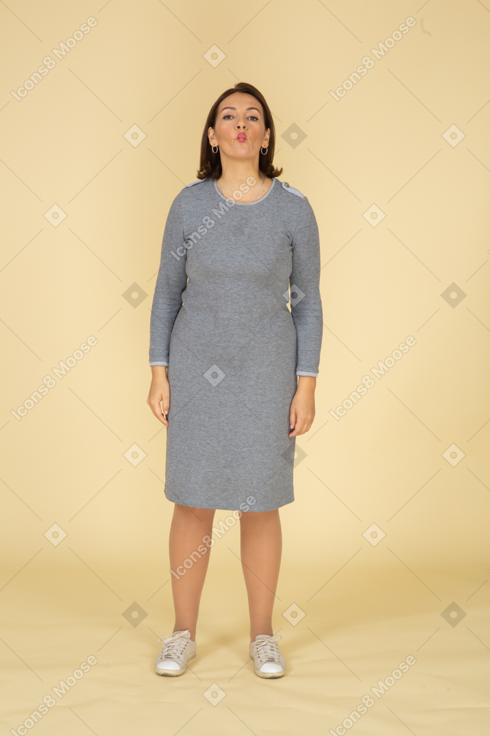 一个穿着灰色裙子的女人在亲吻的前视图