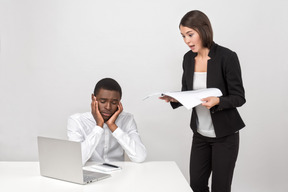 Chefe zangado feminino e seu empregado chateado