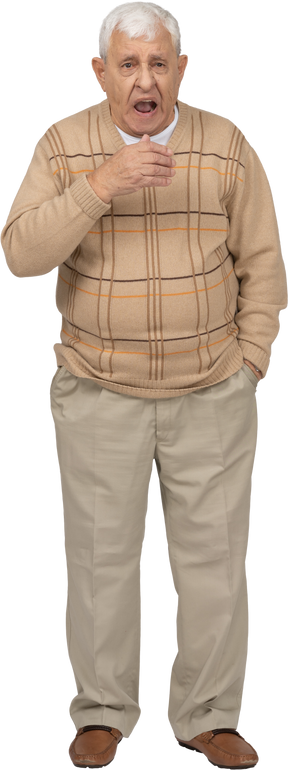 Vista frontal de un anciano con ropa informal bostezando
