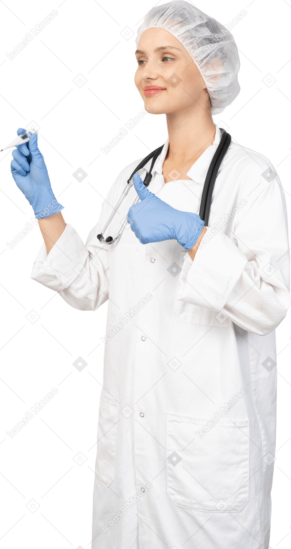 Three-quarter view of a smiling young female doctor with stethoscope holding thermometer and showing thumb up
