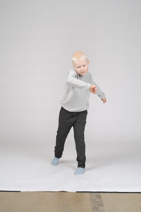Front view of boy in casual clothes spinning around