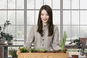 A woman standing behind a wooden box with succulents in it