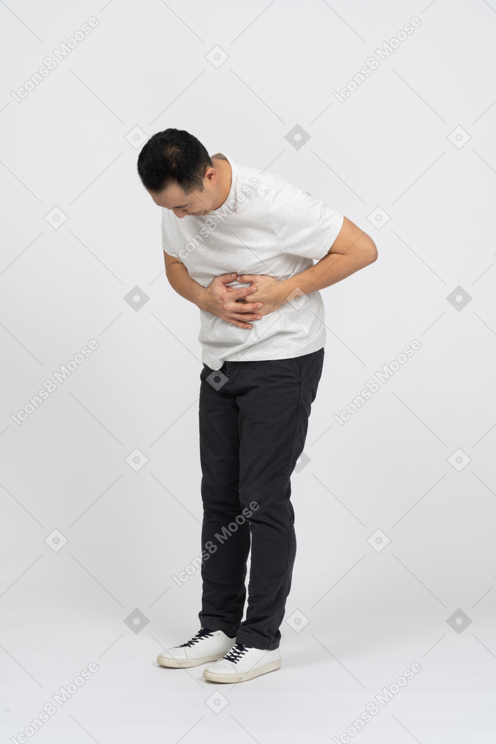 Vista de tres cuartos de un hombre que sufre de dolor de estómago