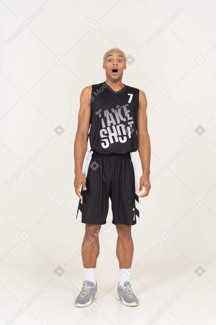 Vista frontale di un giovane giocatore di basket maschile scioccato