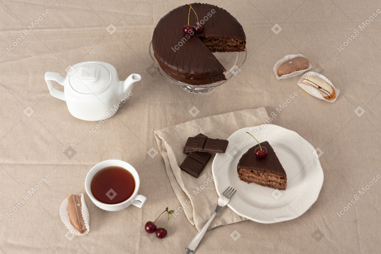 Chocolate cake on cake stand, teapot, cup of tea and piece of cake on the plate